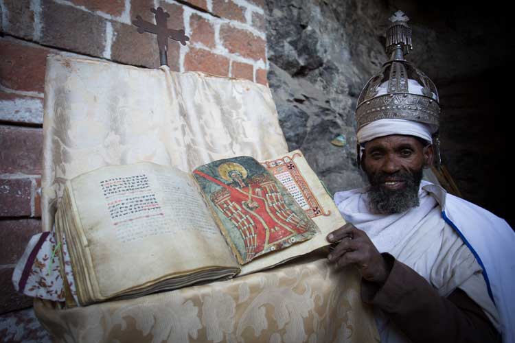 Ethiopia cultural tour slide of a Priest with bible in Lalibela
