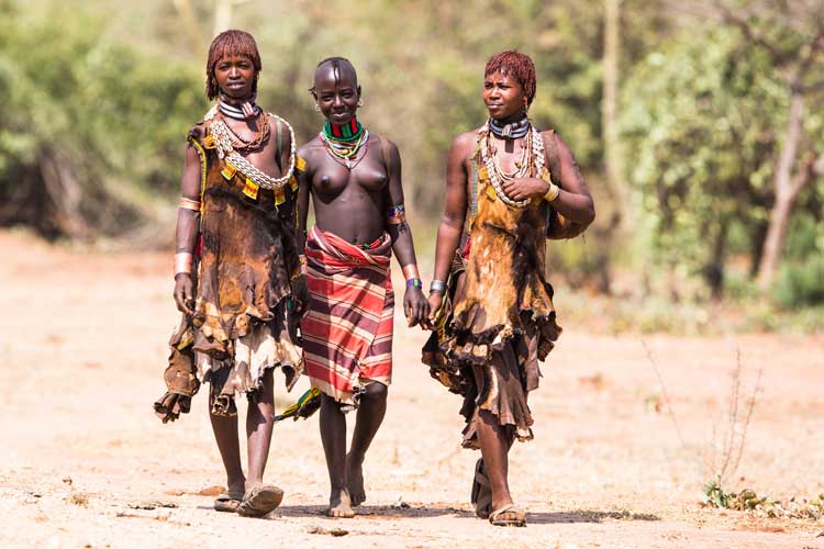 Ethiopia travel image shows Hamer women in the South Omo Valley walking to market