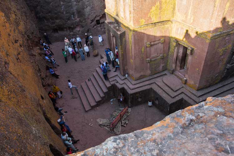 Ethiopia culture slide showing travelers visiting stone church in Lalibela