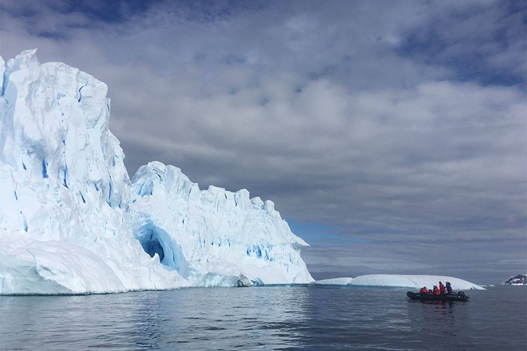 Antarctica ice with zodiac approaching iceberg on Antarctic Peninsula