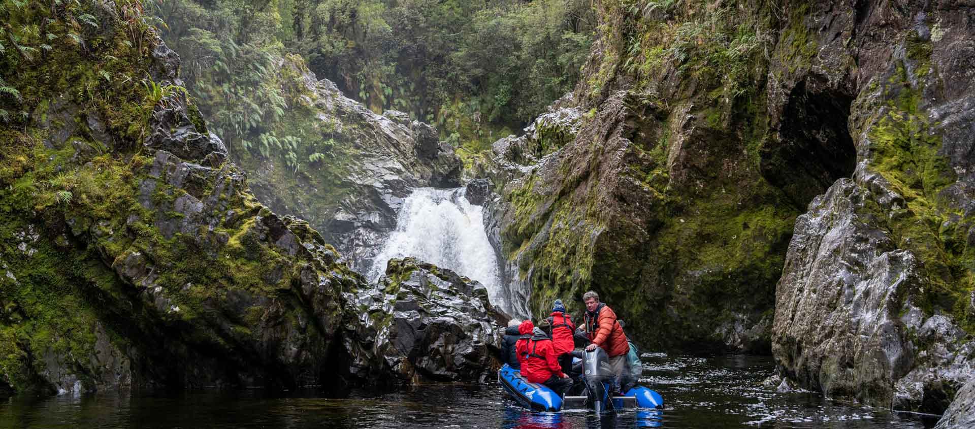 New Zealand South Island with Fiordland cruise image showing Zodiac at waterfall